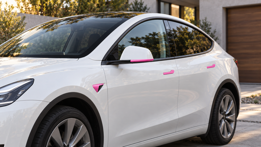 White Model Y-style electric crossover with glossy fuchsia door handle, side camera housing, and mirror trim accessories installed