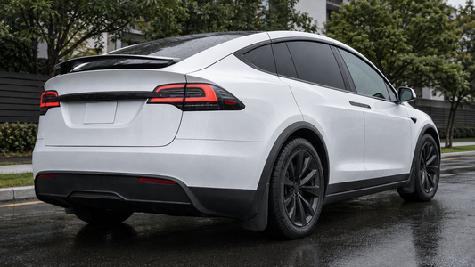 Black front and rear mud flaps installed on a white 2022–2026 Model X after rain