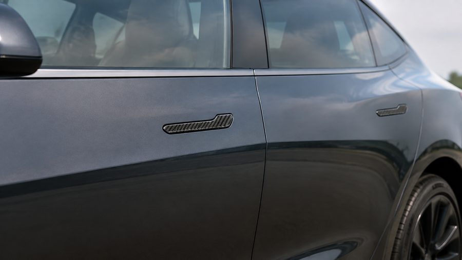 Real carbon fiber resin door handle covers installed on a dark gray Model 3 or Model Y