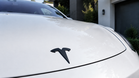 Matte black Tesheer front emblem cover installed on a pearl-white Model 3 hood