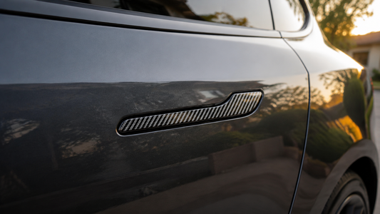 Glossy carbon fiber-textured ABS door handle cover installed on a dark gray Tesla Model 3