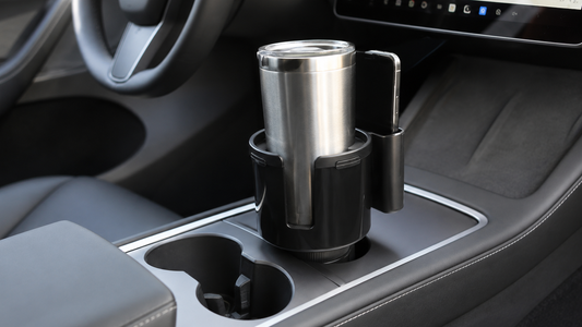 Black adjustable cup holder expander installed in a Tesla Model 3 or Model Y center console with a large travel tumbler and phone