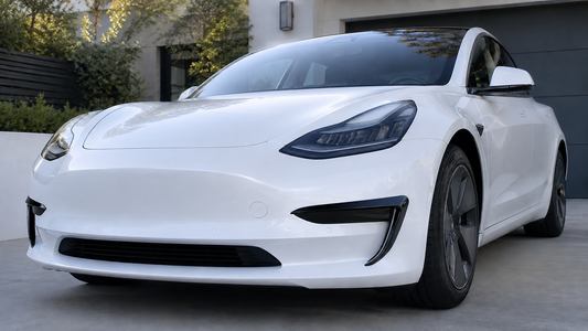 Glossy black fog light trim covers installed on a white 2017-2023 Tesla Model 3