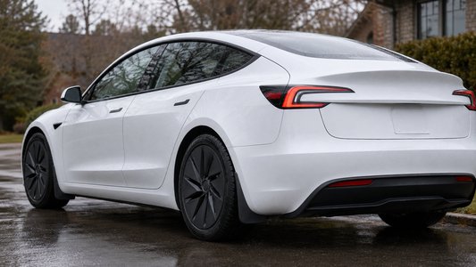 White 2024–2026 Tesla Model 3 Highland with black Tesheer mud flaps installed on a damp driveway