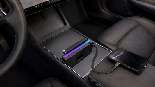 Retractable RGB USB hub installed in a Model 3 Highland center console with one USB-C cable charging a phone