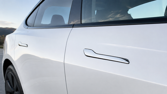 Silver stainless steel door handle covers installed on a white Model 3 or Model Y