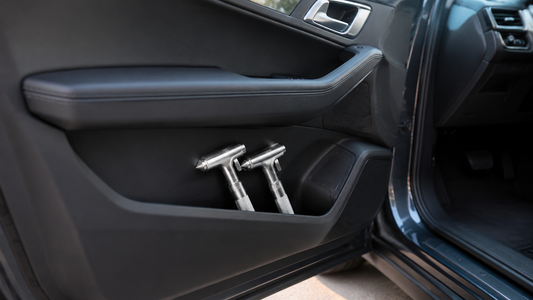 Two silver Tesheer car escape hammers stored within reach in a driver-side door pocket