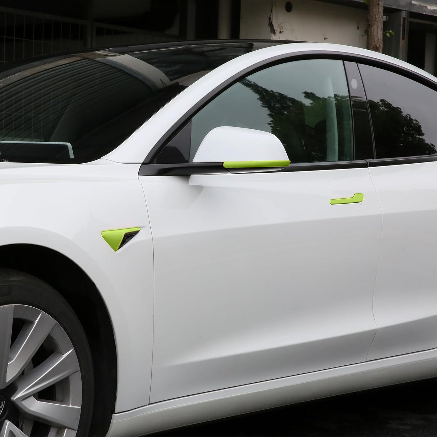 Side angle view of Tesla Model Y Juniper with green camera cover and mirror trim installed