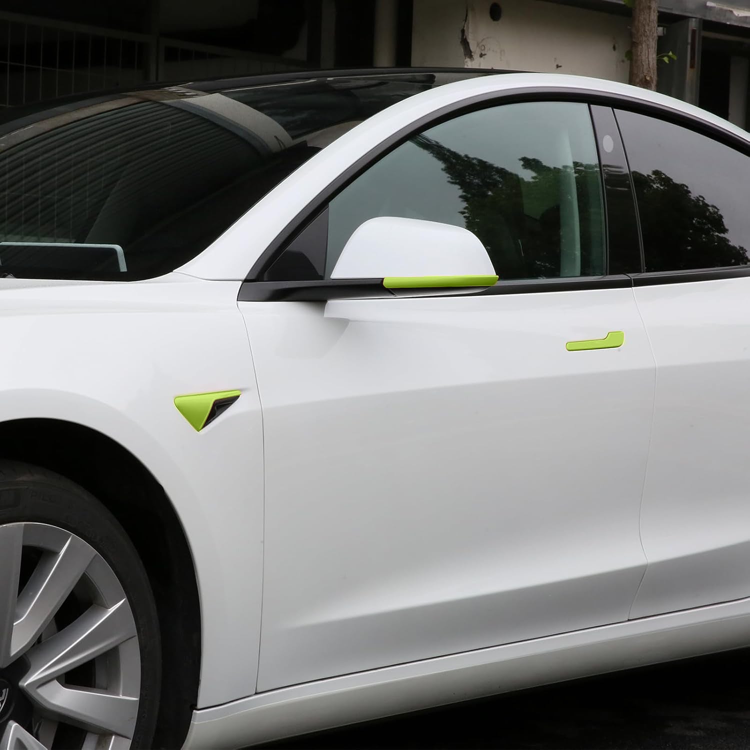 Side angle view of Tesla Model Y Juniper with green camera cover and mirror trim installed
